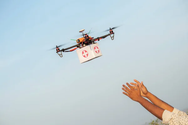Drone Delivering First Aid Box or medicine to costumer hand during covid-19 or coronavirus lockdown - Advancing Medical Industry Logistics for Drug Transport concept