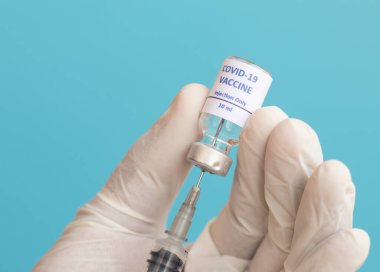 Doktor, Covid-19 ya da Coronavirus aşısını şişeden almak için şırınga kullanıyor - Covid-19 Aşı, Araştırma, dünya çapında salgın grip aşıları.