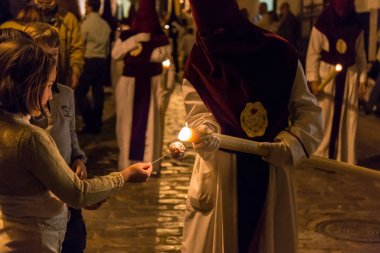 Çocuk bir Nazarene mum balmumu toplama