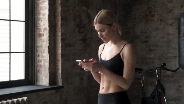 年轻女子在健身锻炼过程中使用智能手机进行跟踪 慢动作视频 — 图库视频影像