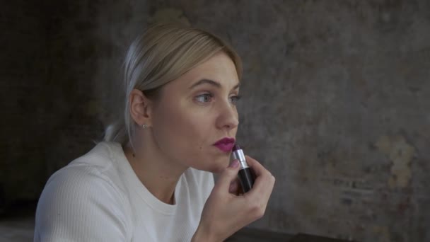 Vrouw Schildert Haar Lippen Met Lippenstift Een Zwarte Achtergrond Blonde — Stockvideo