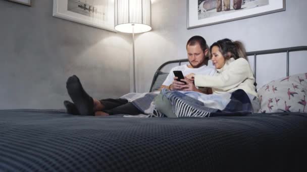 夫妻二人躺在床上 手里拿着手机 — 图库视频影像