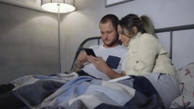Akıllı Telefon Kullanarak Yatakta Yatan Genç Çift
