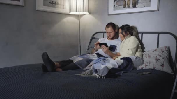 Mann Und Frau Mit Smartphone Lachend Hause Bett — Stockvideo