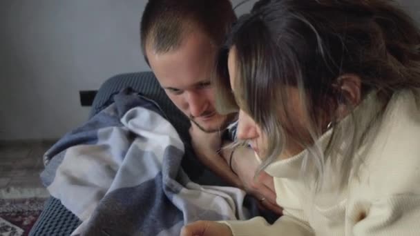 这对快乐的夫妇用智能手机看照片 躺在床上 年轻男人和女人聊天 在一起 — 图库视频影像