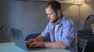 İşadamı odaklı girişimci dizüstü bilgisayarla araştırma yapıyor. Bilgisayarı kullanan genç profesyonel bir erkek ofis masasında oturuyor. Modern teknoloji not defteri üzerinde çalışan meşgul bir işçi..