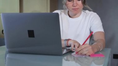 İnternette internet öğretmeniyle ciddi öğrenci çalışması. Dil konuşmayı öğreniyor. Dizüstü bilgisayarına bakıyor.