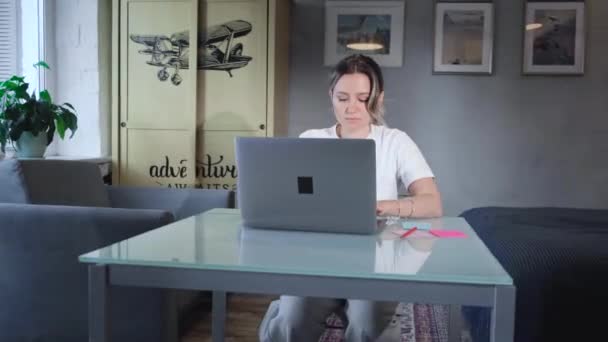 穿着休闲装的成熟女商人坐在灰色的沙发上 在家里的笔记本电脑上工作 迷人的女士在网上解决紧急问题 — 图库视频影像