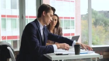 Kadın ve erkek rahat modern ofiste masada oturarak çalışırlar. Çalışma süreci. Yaratıcı iş ekibi toplantısı.