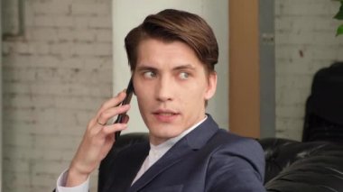 İş adamı toplantı odasında cep telefonuyla konuşuyor.