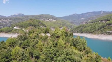 AERİAL Panoramik Manzara: Muhteşem bir dağ nehri olan ormandaki yeşil ağaçların havadan görünüşü. Yeşil dağlarda sabah sisi ve güzel bir nehir. 4k video kaydı