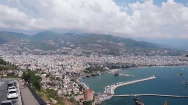 Bulutlu Gökyüzü ile Deniz Koyu 'nun karşısındaki Resort City manzarası. Şehir, Adriyatik denizi, sahil, liman, sahil, palmiye ağaçları ve şehri savunmak için eski kalenin hava görüntüleri