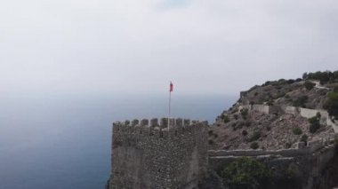 Eski kale, Alanya, Türkiye. Kizil Kule (Kızıl Kule) - Türkiye 'nin Alanya kentinin başlıca turistik merkezi. Bina şehrin sembolü olarak kabul ediliyor ve hatta şehrin bayrağında bile kullanılıyor..