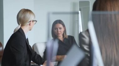İki genç kız sandalyeye oturur ve iş hakkında konuşur. Kızlar gülümser ve iletişim kurar. İş toplantısındaki iki kadın yeni bir proje hakkında iş arkadaşlarıyla konuşuyor.