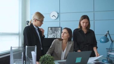Üç genç kız ofislerinde iş konuşuyorlar ve evrakları kontrol ediyorlar. Kızlar gülümser ve iletişim kurar. İş toplantısında üç kadın yeni bir proje hakkında iş arkadaşlarıyla konuşuyor..