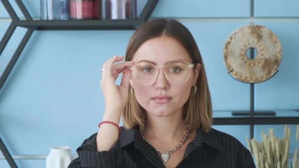 Mujer Ajusta Sus Gafas Cara Mira Directamente Cámara — Vídeos de Stock