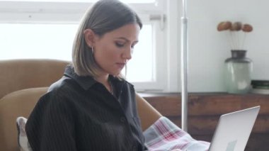 Yakın çekim: geceleri evdeki oturma odasında bilgisayarla çalışan serbest çalışan iş kadınları. Kız evde oturuyor ve çalışıyor..