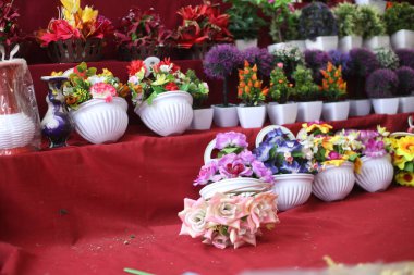 Dükkanda yapay çiçek, rafta sahte renkli çiçekler..