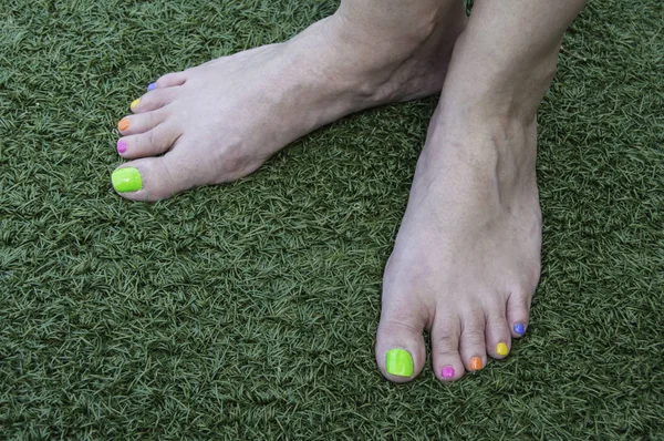 Füße mit farbigen Nägeln — Stockfoto