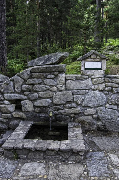 Деревенский каменный фонтан — стоковое фото