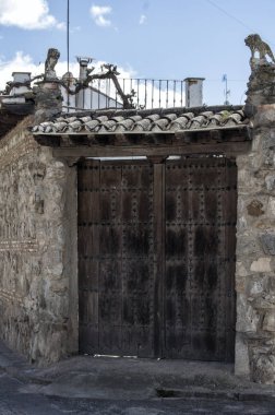 Büyük bir ahşap kapı / ahşap kapı Puebla de Montalban, Toledo eyaletinde bir evde bir taş cephe çatı ile. Castilla la Mancha İspanya.