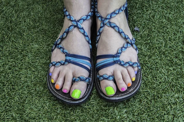 Füße Mit Sandalen Füße Mit Blauen Sommersandalen Und Bunt Lackierten Stockbild