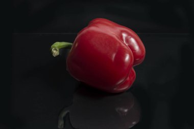 Siyah arkaplanda yansıması olan kırmızı biber