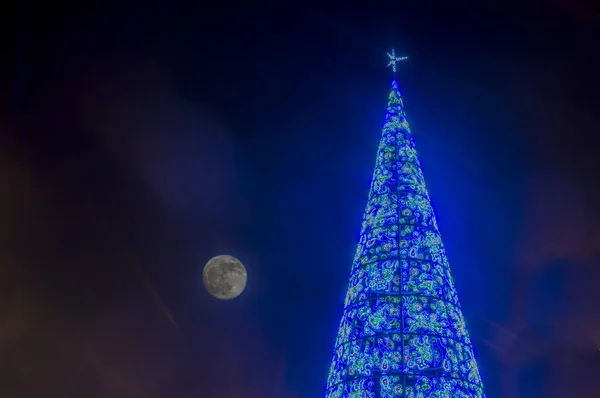 Tree of blue lights and the moon in Madrid. Spain