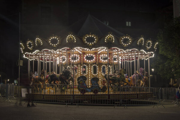 a Christmas carousel illuminated at night insquare in  Madrid. Spain