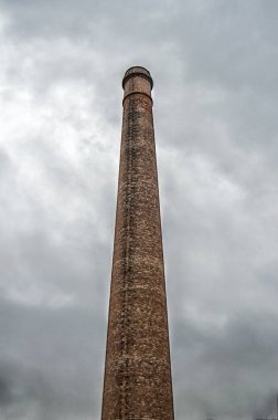 Madrid 'de bir bahçede eski tuğla bacası. İspanya.