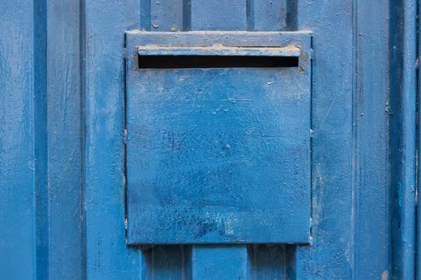 Mavi metalik kapıdaki posta kutusu
