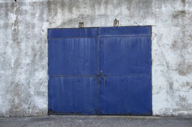İspanya 'da eski bir kerhanenin girişindeki mavi metalik kapı.