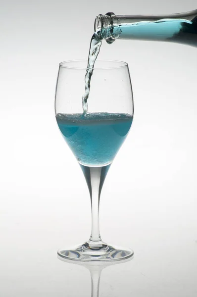 Una Botella Que Vierte Licor Azul Vaso Aislado Sobre Fondo — Foto de Stock