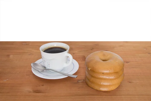 Vier Bagel Gestapelt Mit Einer Tasse Kaffee Isoliert Auf Holzgrund — Stockfoto