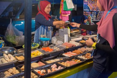 Kuala Terengganu, Malezya - 13 Ocak 2017. Değişiklik geri onun müşteriye vererek bir hawker.