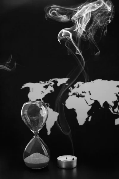 Zwart-wit beeld, wereldkaart, sandglass en verbrande kaars, overeenkomen met — Stockfoto