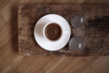 Kahve molası, beyaz fincan kahve, kum saati, ahşap arka plan,