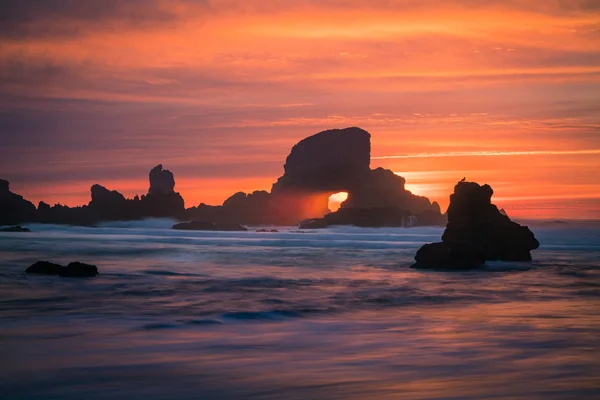 Pôr do sol atrás do arco na costa de Oregon EUA — Fotografia de Stock