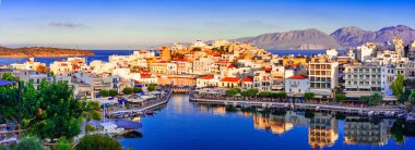 Agios Nikolaos, Girit, Yunanistan: Agios Nikolaos 'un Voulismeni Gölü üzerindeki günbatımı manzarası, Girit adasının doğu kesiminde, Mirabello körfezinin kuzeybatı yakasında yer alan pitoresk bir kasaba