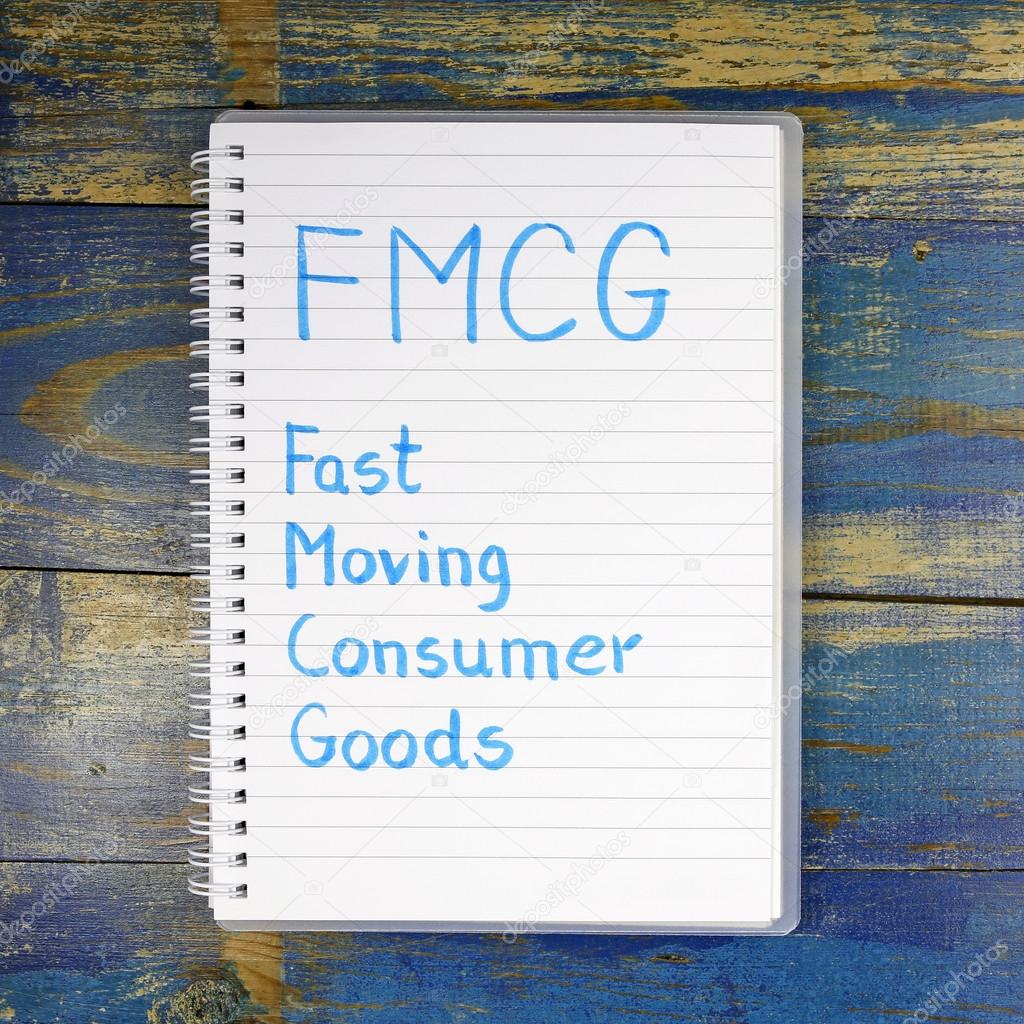 FMCG- Fast Moving Consumer Goods written in notebook on wooden background