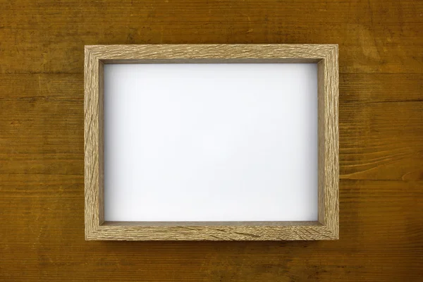 Wooden frame with white card on wooden wall — Stock Photo, Image