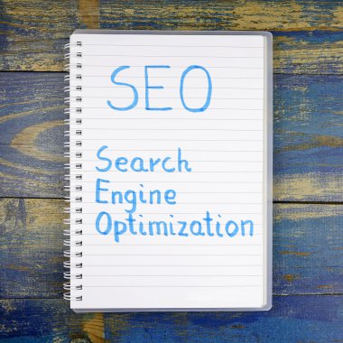 SEO - arama motoru üzerinde ahşap arka plan defterde yazılı optimizasyonu