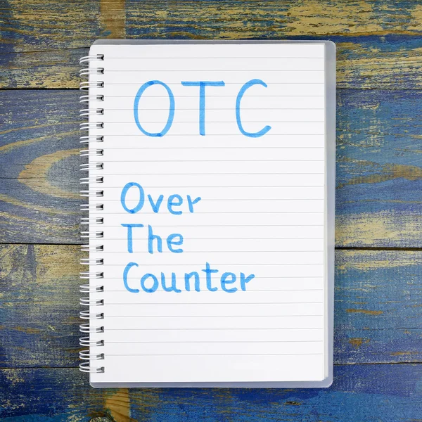 OTC- Over The Counter written in notebook on wooden background