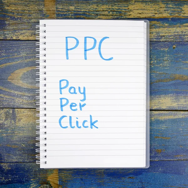 Ppc- pay per click in Notizbuch auf Holzgrund geschrieben — Stockfoto