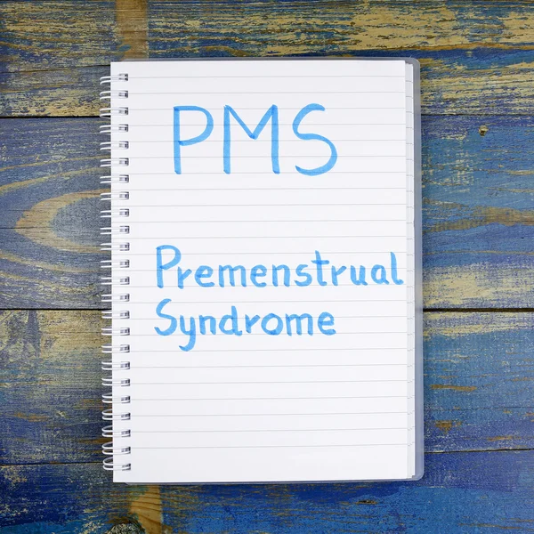 Pms ・月経前症候群の木製の背景にノートに書かれました。 — ストック写真
