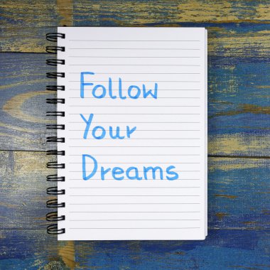 Ahşap arka plan üzerinde defterde yazılı Your Dreams metin izleyin