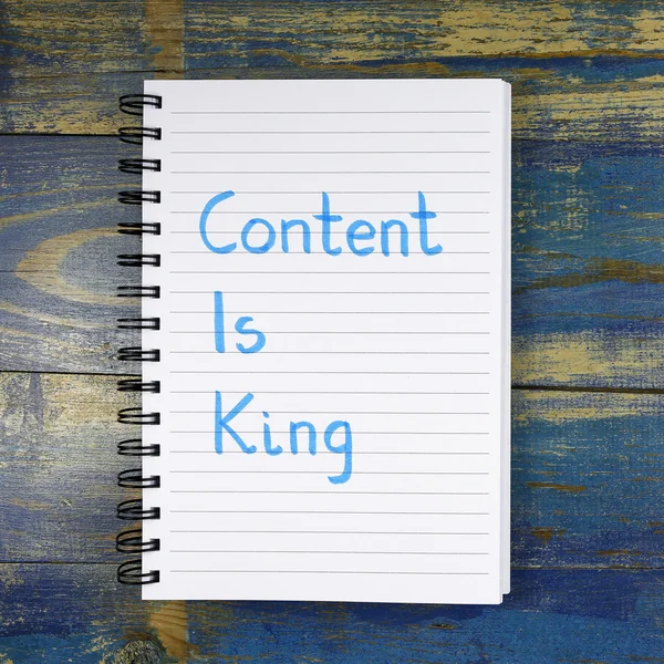 Content Is King written in notebook on wooden background