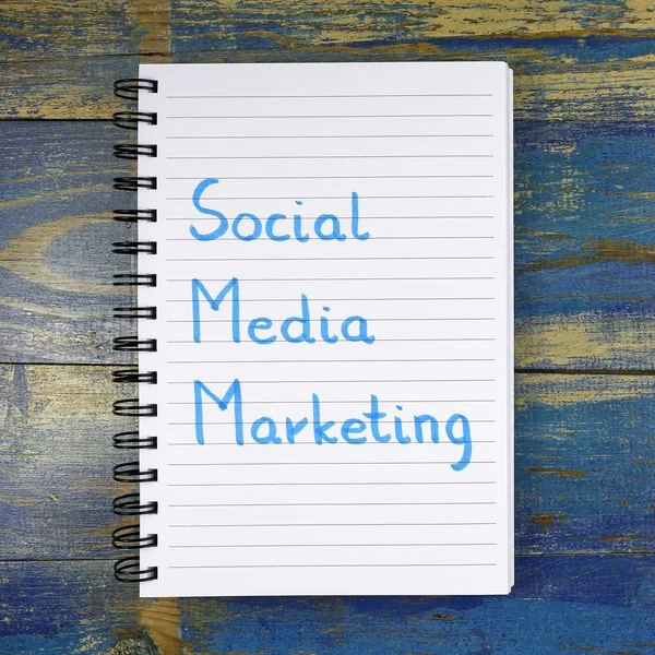 Social Media Marketing text written in notebook on wooden background — Stock fotografie