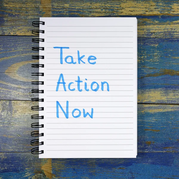Take Action Now text written in notebook on wooden background — Stock Photo, Image