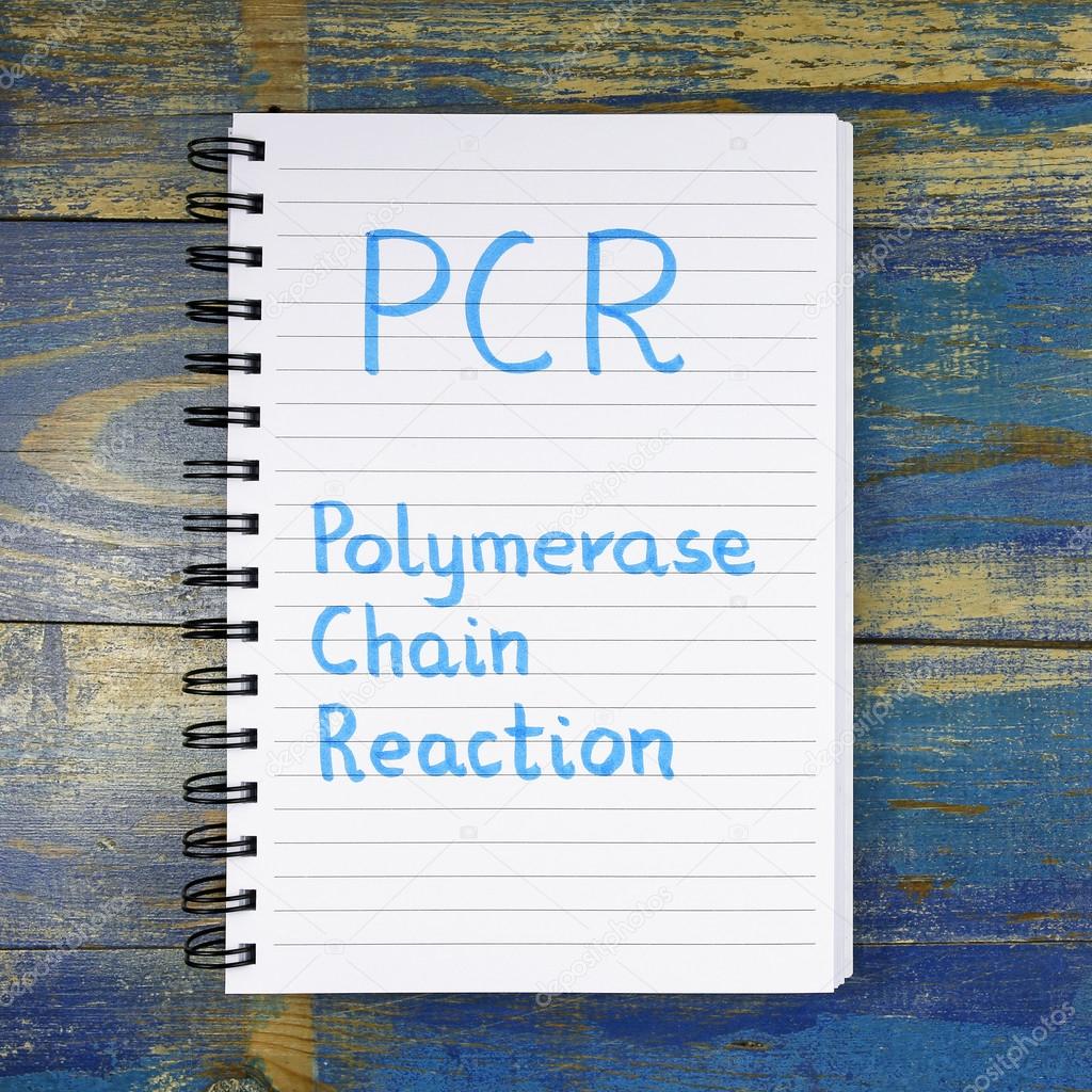PCR- Polymerase Chain Reaction acronym written in notebook on wooden background